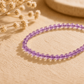Amethyst crystal bracelet with small purple beads in warm natural light