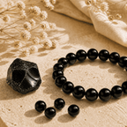 Black obsidian bracelet with a natural obsidian stone and loose polished beads in warm sunlight