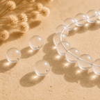 Close-up of a clear quartz bead bracelet and loose drilled crystal beads sparkling in sunlight