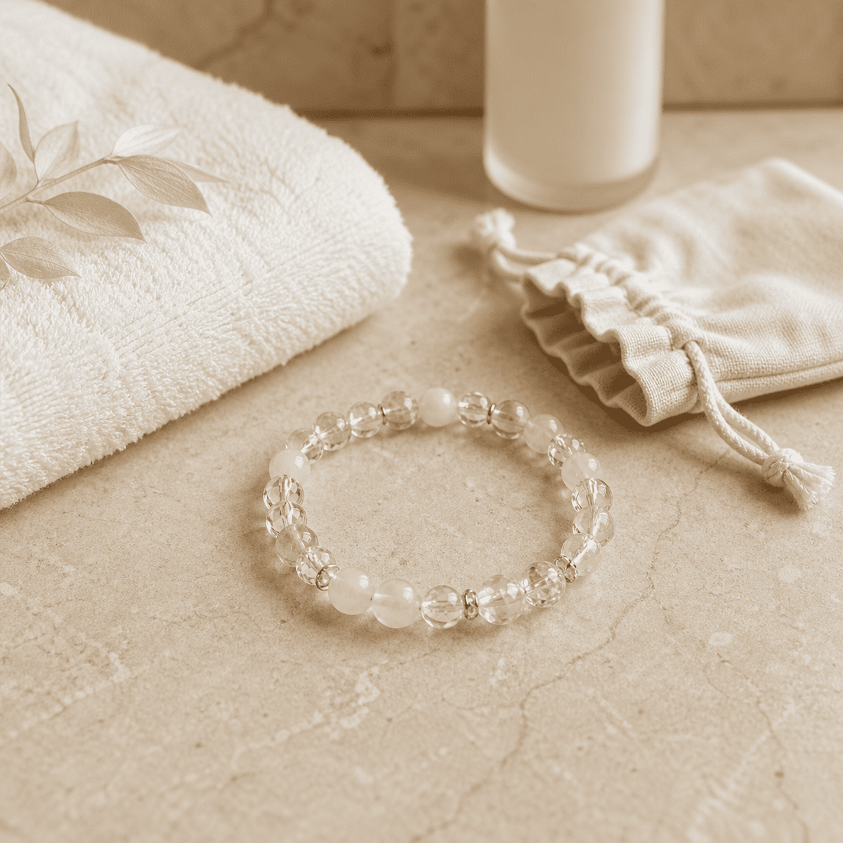 Clear and white crystal bead bracelet displayed with a towel candle and cotton pouch