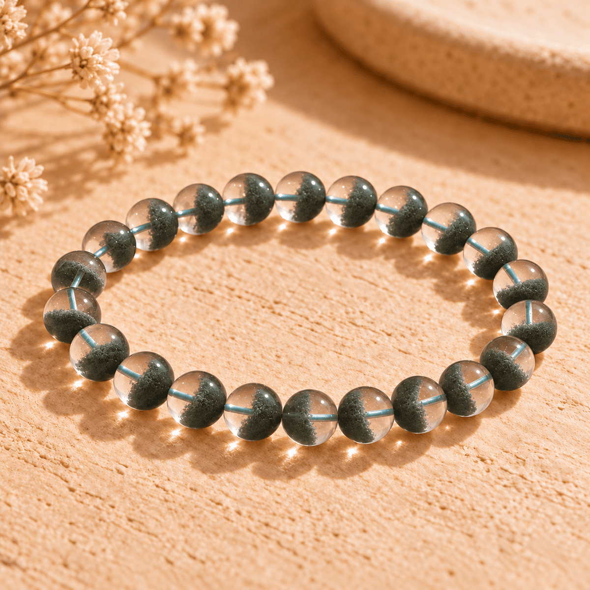 Green phantom crystal bracelet with clear round beads and dense green inclusions concentrated in the lower half