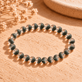 Green phantom crystal bracelet arranged in a wide oval, with green inclusions visible through clear round beads