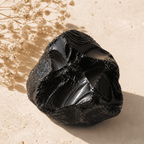 Natural black obsidian stone displayed in warm sunlight as the material used for an obsidian stone bracelet