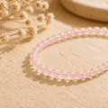 Pink crystal bracelet with small polished beads arranged in warm natural light